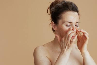 Mulher realizando esfoliacao facial