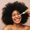 Mulher aplicando serum com peptideos de colageno no rosto com auxilio de um gotejador