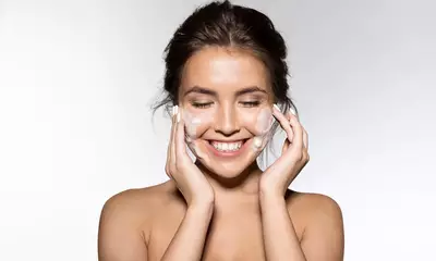 Mulher lavando o rosto com sabonete para pele seca