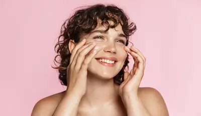 Mulher de pele clara aplicando hidratante facial