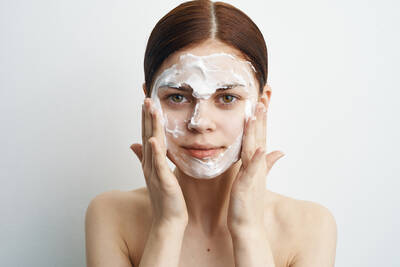 Mulher branca realizando a limpeza de pele com produtos de limpeza para pele oleosa menopausa