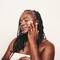 Mulher passando acido retinoico, um derivado da vitamina A usado para tratar acne, envelhecimento e manchas na pele.