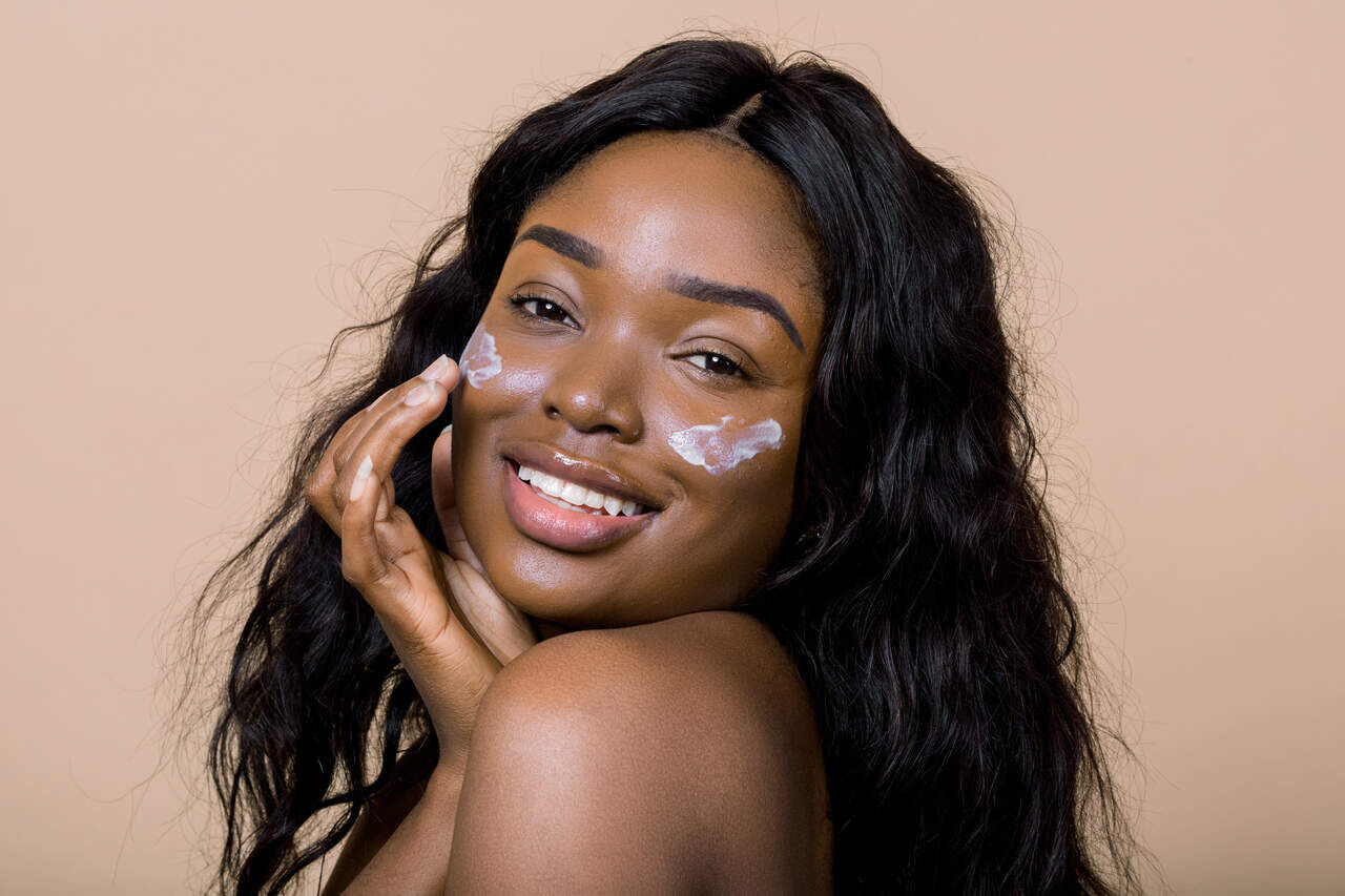 Mulher usando protetor solar para pele negra