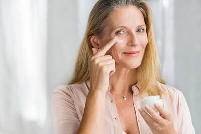 Mulher aplicando creme para rugas antissinais