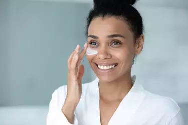 Mulher aplicando creme para olheiras