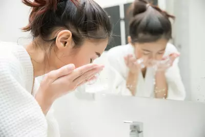 Mulher aplicando sabonete neutro no rosto - Dermaclub