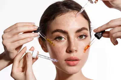 Mulher com vitamina C pura ou derivada para cuidados com a pele sendo aplicados no rosto