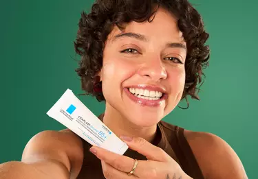 Mulher jovem segurando Cicaplast Baume B5+