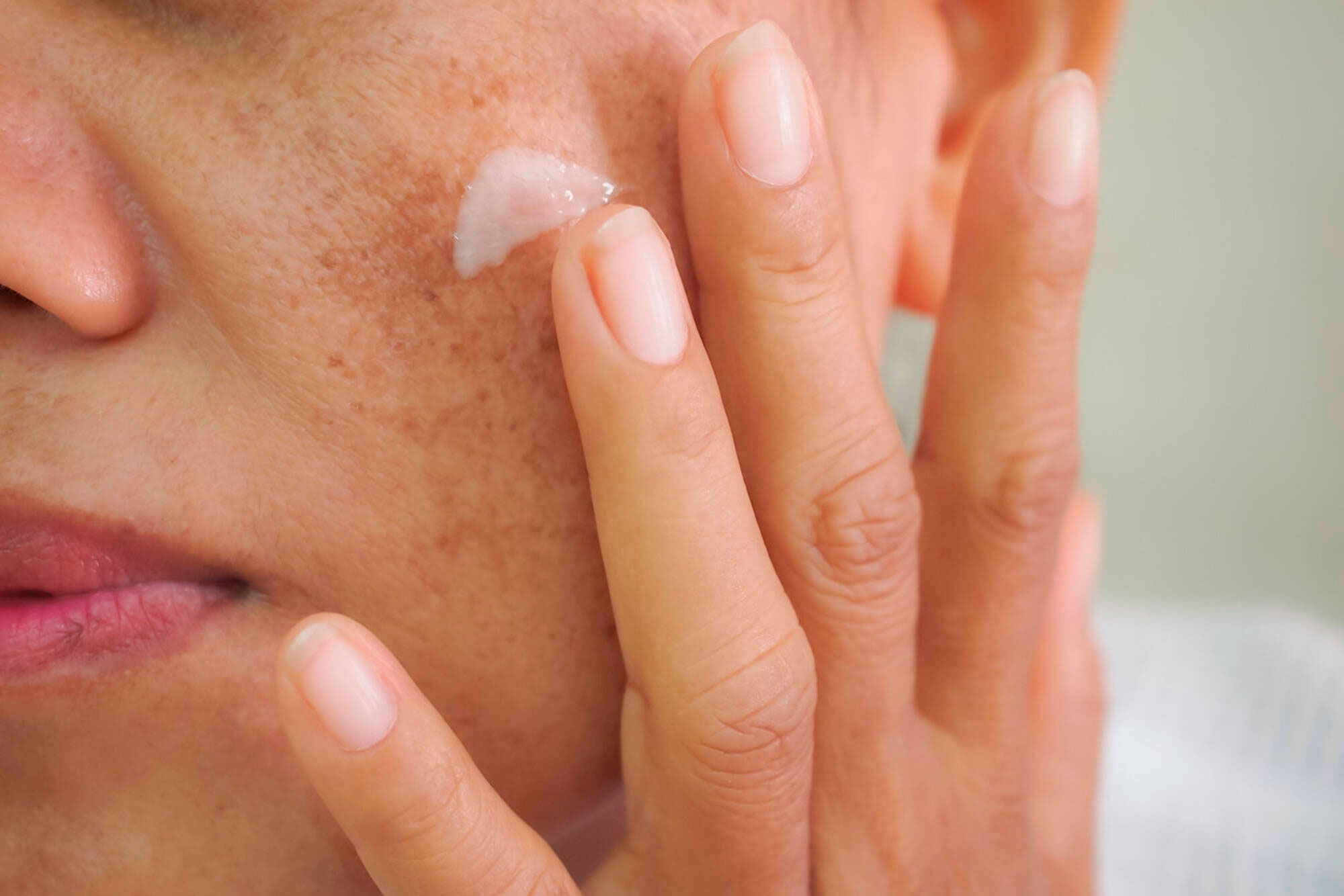 Mulher passando protetor solar