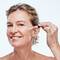 Mulher madura passando serum facial clareador no rosto