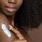 Mulher aplicando produto com ceramidas na pele negra