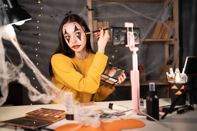 Mulher aplicando maquiagem de halloween