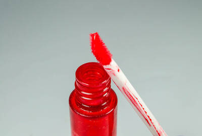 Mulher jovem passando esfoliante labial com os dedos