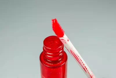 Mulher jovem passando esfoliante labial com os dedos