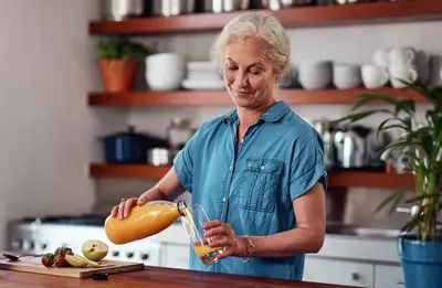 Mulher que sofre com falta de vitamina C tomando suco de laranja