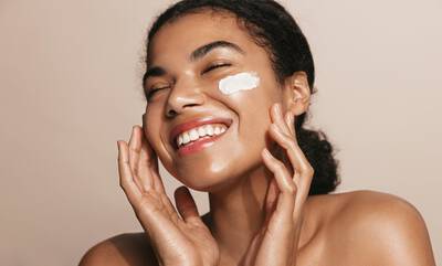 Mulher utilizando creme hidratante para o rosto