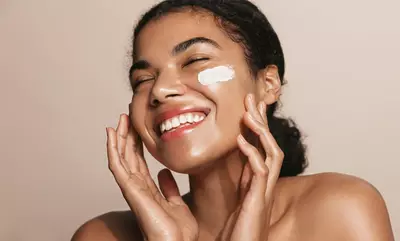 Mulher utilizando creme hidratante para o rosto