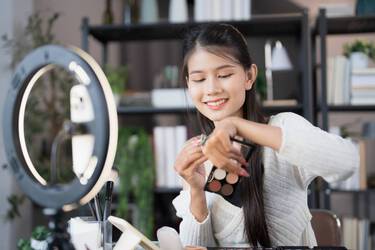 Mulher coreana aplicando maquiagem com primer