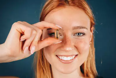 Capsulas de omega-3, destacando os beneficios do nutriente para a saude da pele.