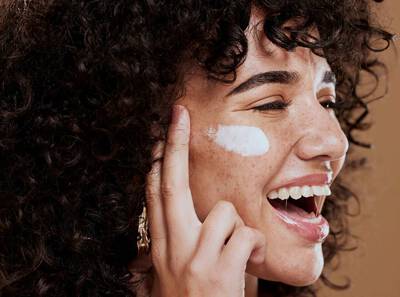 Mulher usando protetor solar para melasma
