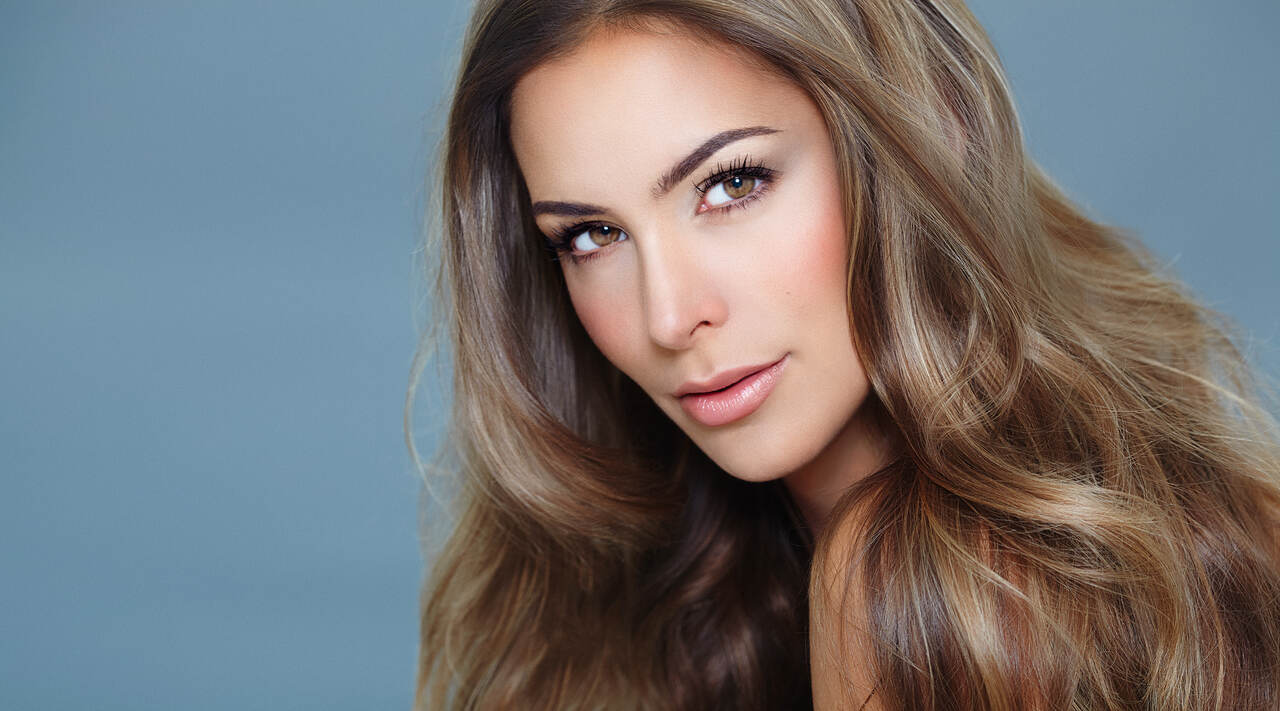 Mulher com cabelo morena iluminada mel na técnica babylights ou luzes