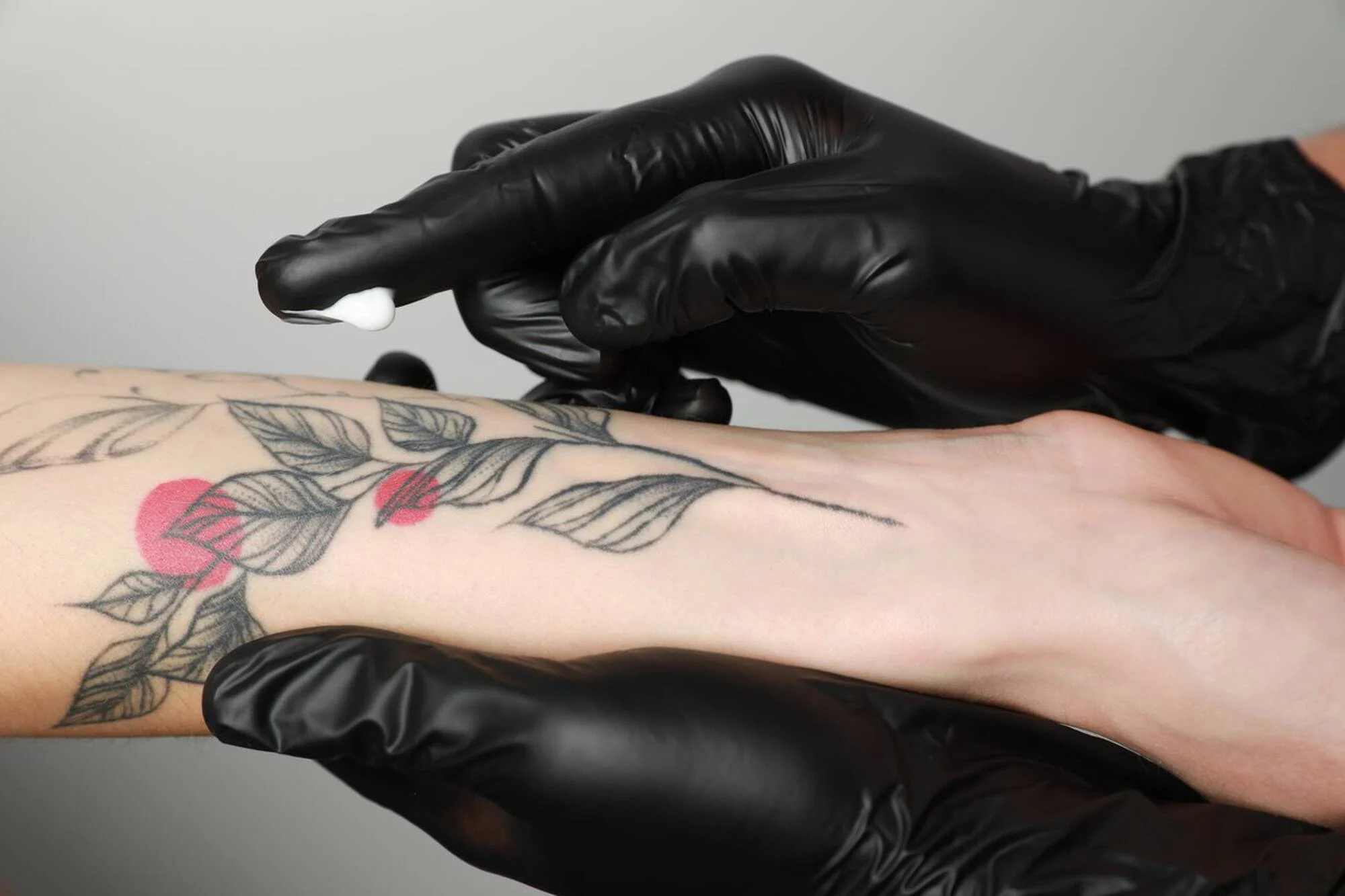 Tatuador passando pomada para tatuagem