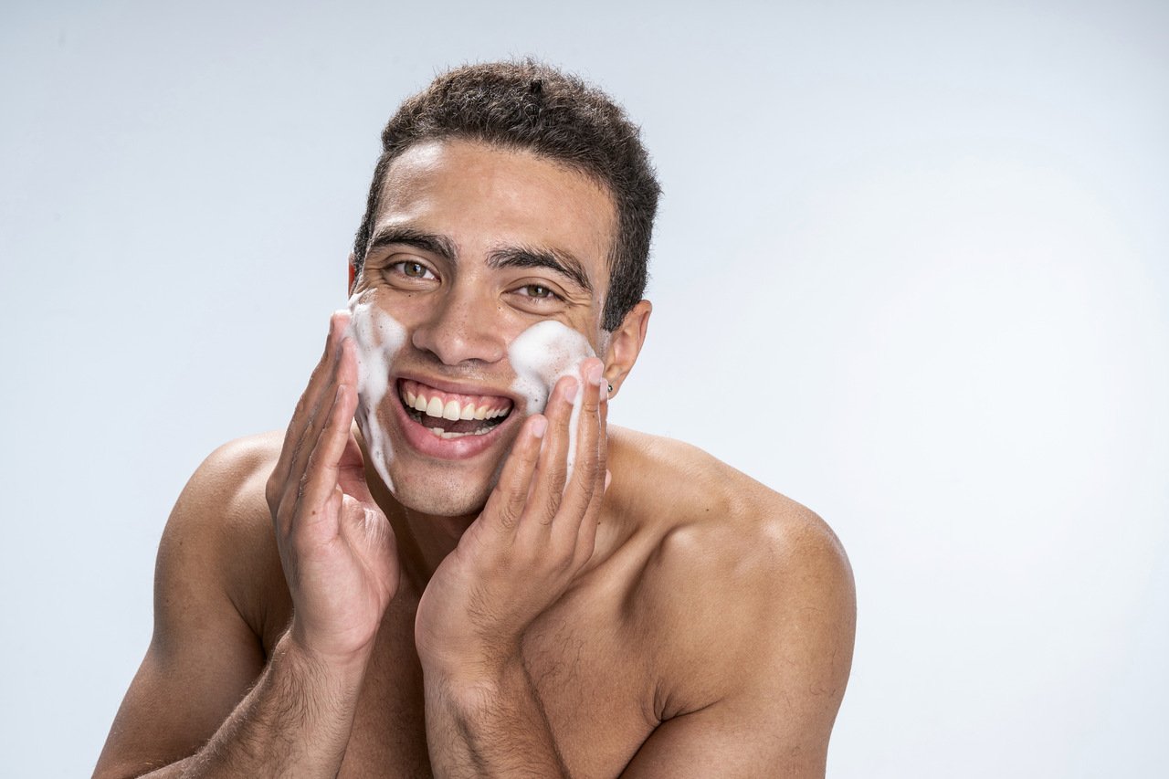 Homem jovem fazendo double cleansing com óleo de limpeza