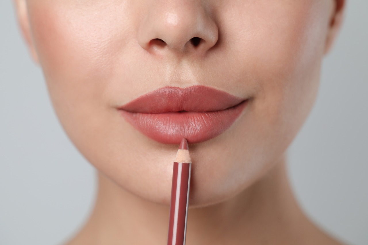 Mulher fazendo lip combos com lápis labial