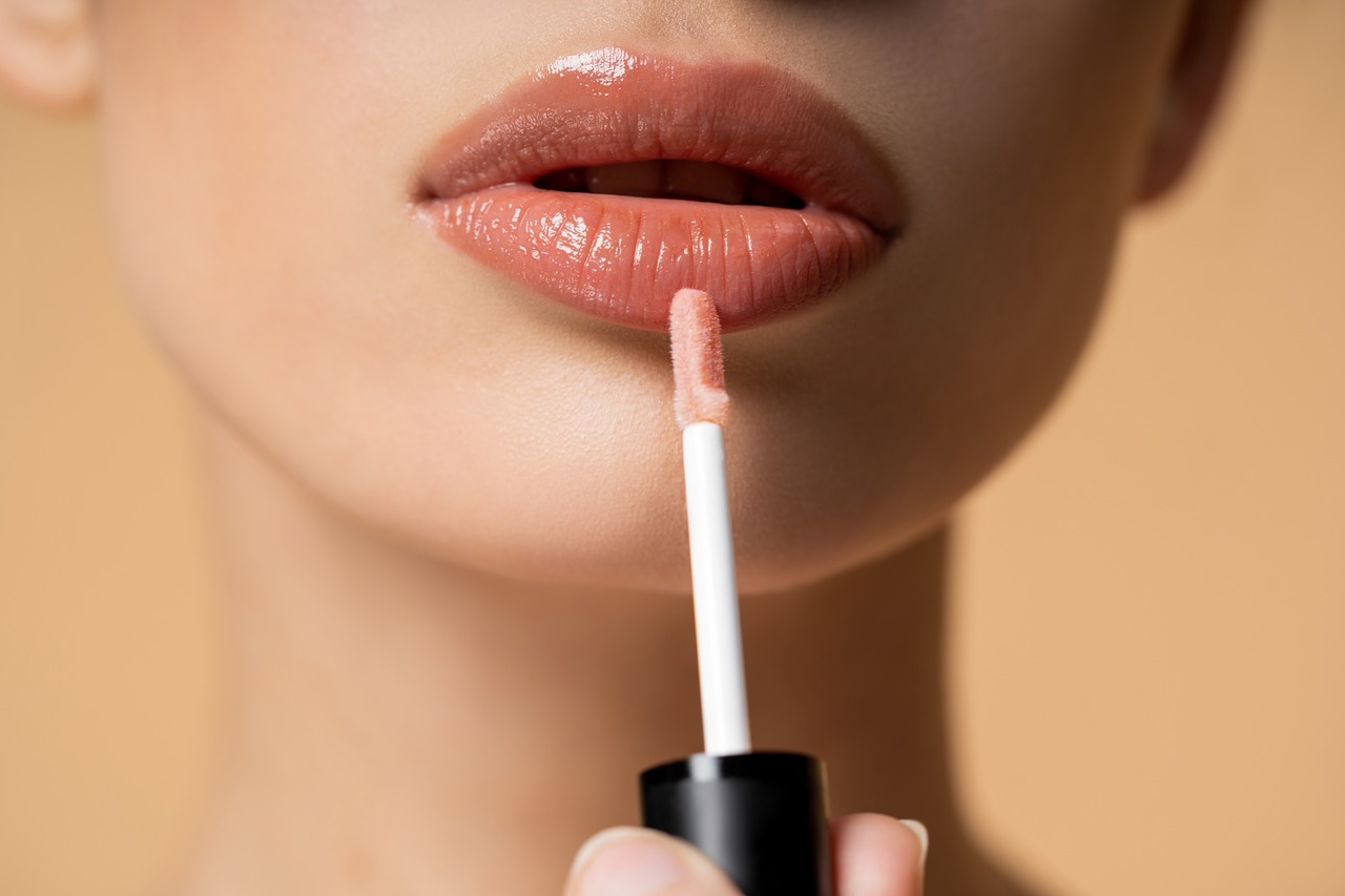 Mulher passando gloss para fazer lip combo