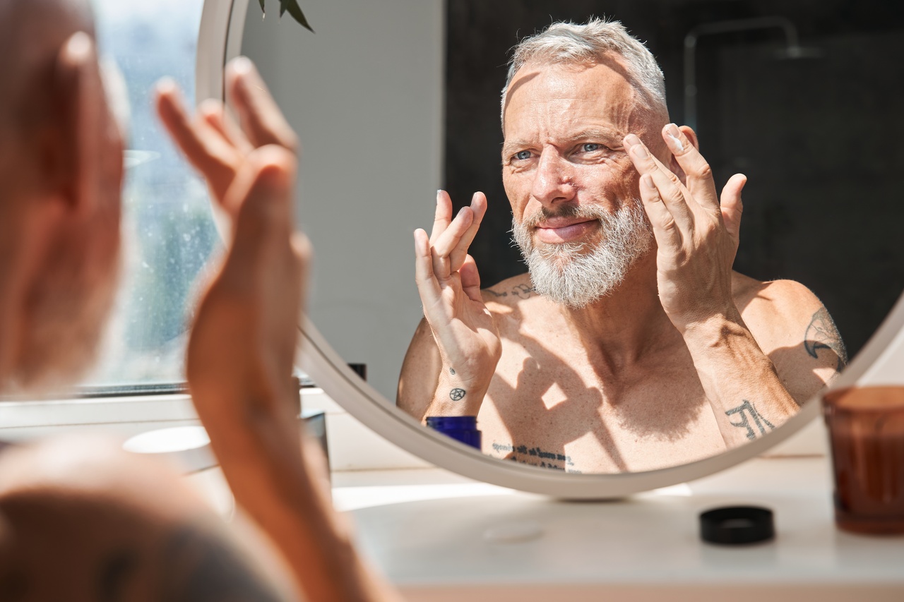 Homem estimulando colágeno com creme com peptídeos