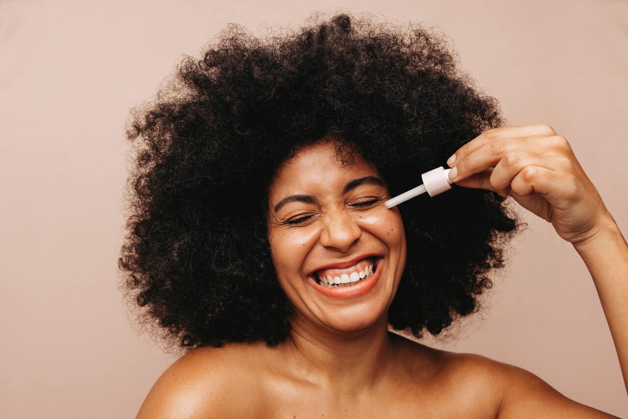 Mulher aplicando hidratante facial para pele oleosa