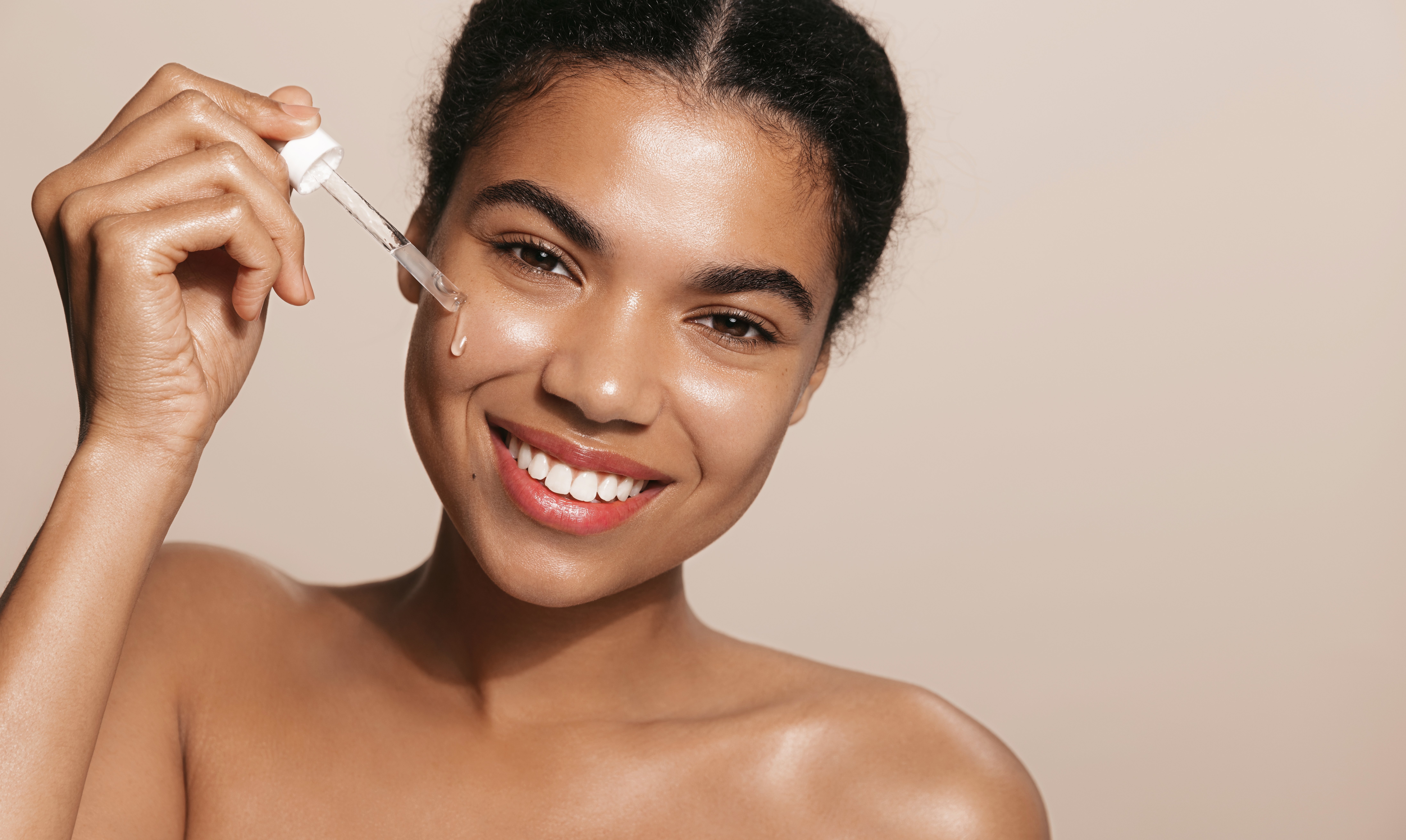 Mulher de pele negra aplicando serum em sua pele
